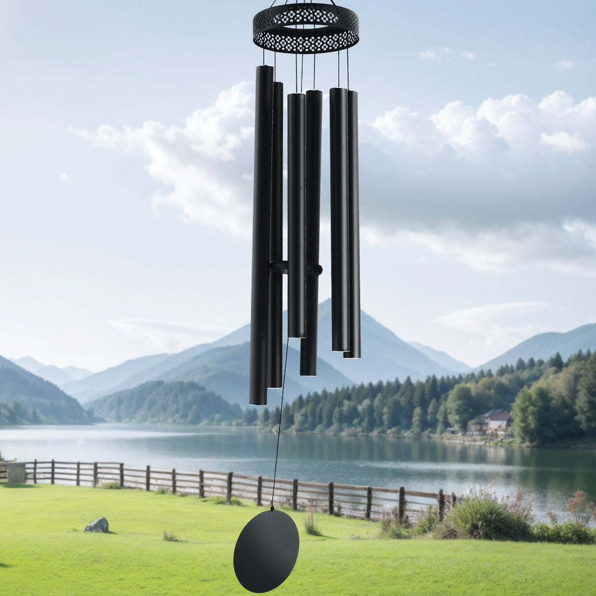Black wind chime against a scenic backdrop of mountains and a lake